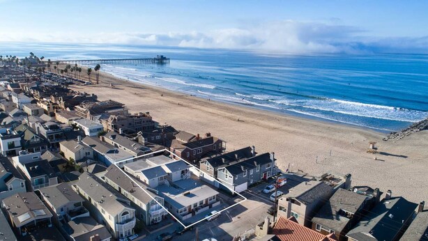 An aerial view of a coastal residential area with houses, a beach, and a pier. - Fantastic upstairs unit just one house from the warm sand (Newport Beach)