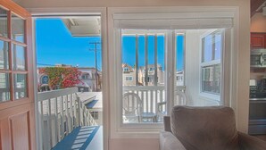 A balcony with a view of neighboring houses and a clear blue sky. - Fantastic upstairs unit just one house from the warm sand (Newport Beach)