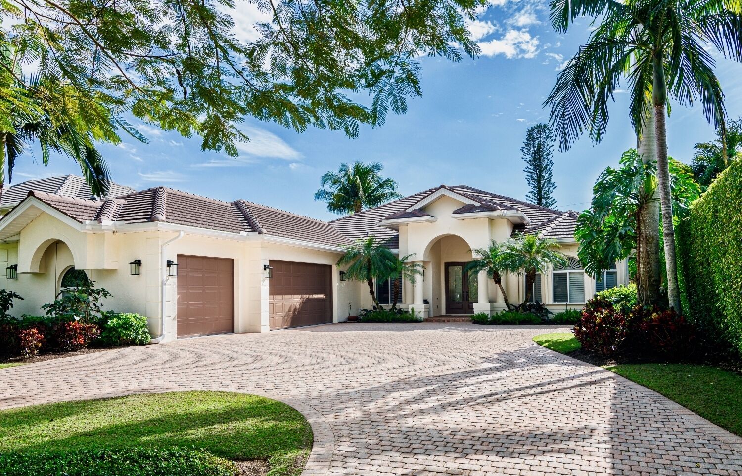 A two-story house with a paved driveway, a garage, and a well-maintained lawn.