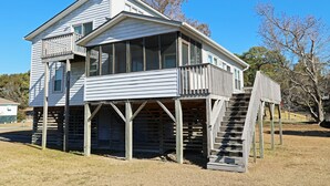 Une maison en bois à deux étages, dotée d’un balcon et d’une véranda.