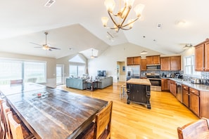 Enjoy a spacious open-plan living area with a dining table and seating, a cozy seating area with sofas, and a fully equipped kitchen.