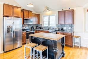 Enjoy cooking in this well-equipped kitchen with a central island, stainless steel appliances, and ample natural light.