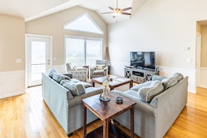 Relax in this inviting living room with a large window, comfortable sofa, and mounted TV.