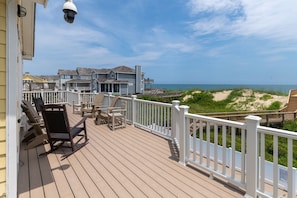 Relax on the oceanfront deck with Adirondack chairs and a small table.