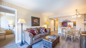 Una sala de estar acogedora con sofá, mesa de centro y una zona de comedor con sillas y una mesa.