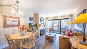 Una sala de estar acogedora con chimenea, un comedor con muebles de madera y un sofá con cojines.