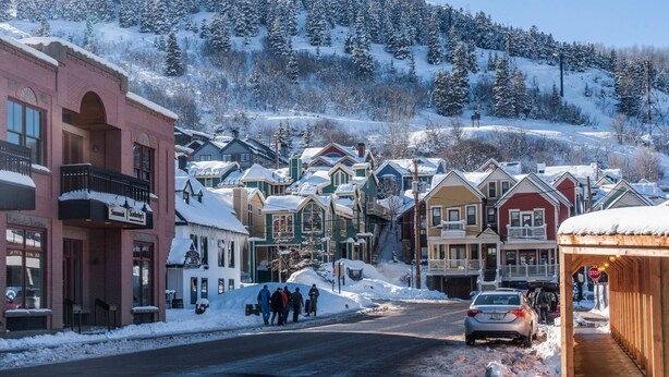 Una calle nevada con casas y un edificio con un letrero que dice "Summit".