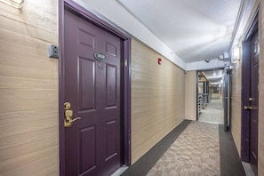A hallway with a purple door marked '302' and a security keypad.