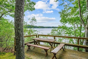 A wooden deck with picnic tables overlooking a lake. - Long Pond Escape—Decks, Kayaks & Fishing (Harwich)