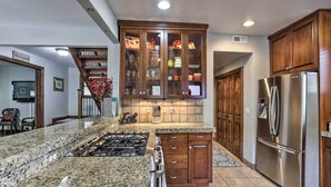 A kitchen with granite countertops, a stainless steel refrigerator, wooden cabinets, and a built-in oven. - Downtown Park City Vacation Rental, Near Ski Lift! (Park City)