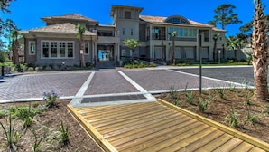 A large, multi-story house with a driveway leading to a gated entrance. - 2311 Racquet Club: 3BR 2 BA Villa. Community Pool and Clay Tennis, Free Bikes (Hilton Head Island)