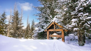 Een houten bord met 'Mountain Star' en het nummer '4894' in een besneeuwd bos.