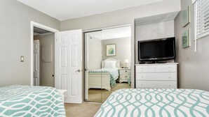A bedroom with two beds, a television, a dresser, and a closet. - Condo# 319 Located across the street from Siesta Key Beach, Gulf and Pool View Condo!! (Sarasota)