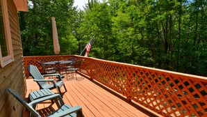 A wooden deck with outdoor furniture, a table, and chairs.
