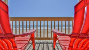 A wooden deck with red chairs facing a beach. - The Choice: Oceanfront Comfort in Surf City (Surf City)