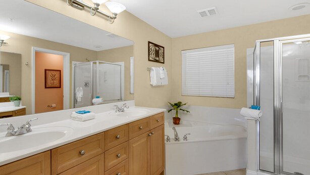 A modern bathroom with a large mirror, two sinks, a bathtub, and a shower. - Balcony has Gorgeous Views of the Sunset Nightly! Steps from the Beach and Pool! (Miramar Beach)