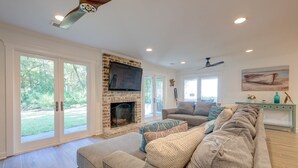 Un salón amplio con chimenea, un televisor de pantalla plana grande y una zona de estar cómoda.