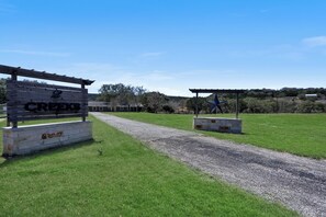 A gravel path leading to a wooden gate labeled "Creeks." - 3 Bedroom/3 Bath home overlooking 2 Creeks with Hot Tub and Fire Pit! (Wimberley)