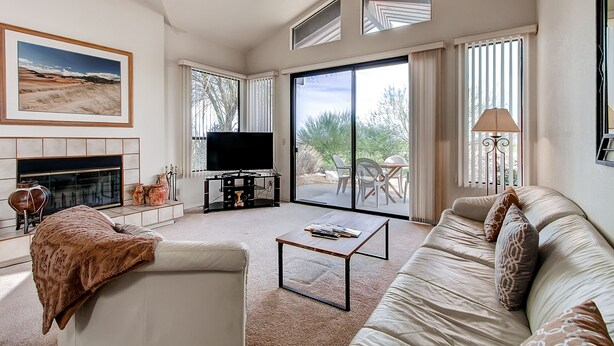 Una sala moderna con chimenea, televisor de pantalla plana, sofá y mesa de centro.