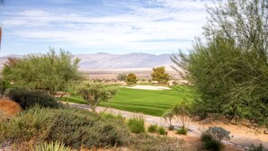 Un campo de golf con vistas despejadas a las montañas al fondo.
