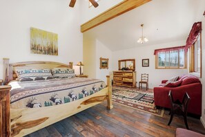 A bedroom with a wooden bed, a red sofa, a wooden dresser, and a window with curtains. - Large Home on 1 Acre: 2 Mi to Grand Lake Village (Grand Lake)