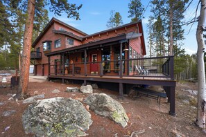 A two-story cabin with a deck, surrounded by trees and rocks. - Large Home on 1 Acre: 2 Mi to Grand Lake Village (Grand Lake)
