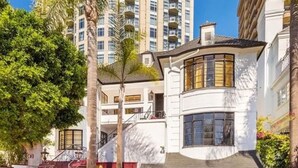 A two-story house with a garage, a staircase, and a large tree in the front yard. - Luxurious 3-Bedroom Westwood Gem  (Los Angeles)