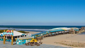 Un muelle de playa con un restaurante llamado 'Cocoa Beach Pier' y una estación de salvavidas.