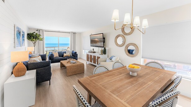 Una sala de estar moderna con una mesa de comedor de madera, sofás y una televisión.