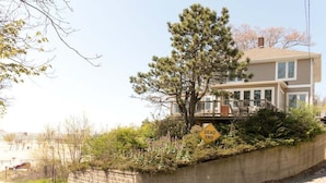 A residential house with a 'DEAD END' sign, a concrete retaining wall, and a tree.