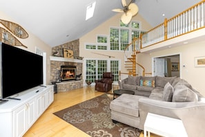 Relax in this inviting living room with a large flat-screen TV, comfortable sofa, and cozy fireplace.