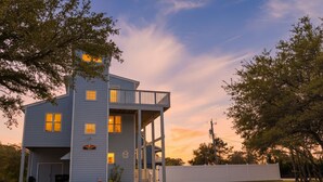 A two-story building with a covered porch and a garage. - Duck Life - Oceanside, Sound View, 325 Yards to Beach, Pool, Hot Tub, Tiki Bar, Pool Table, Pets OK (Duck)
