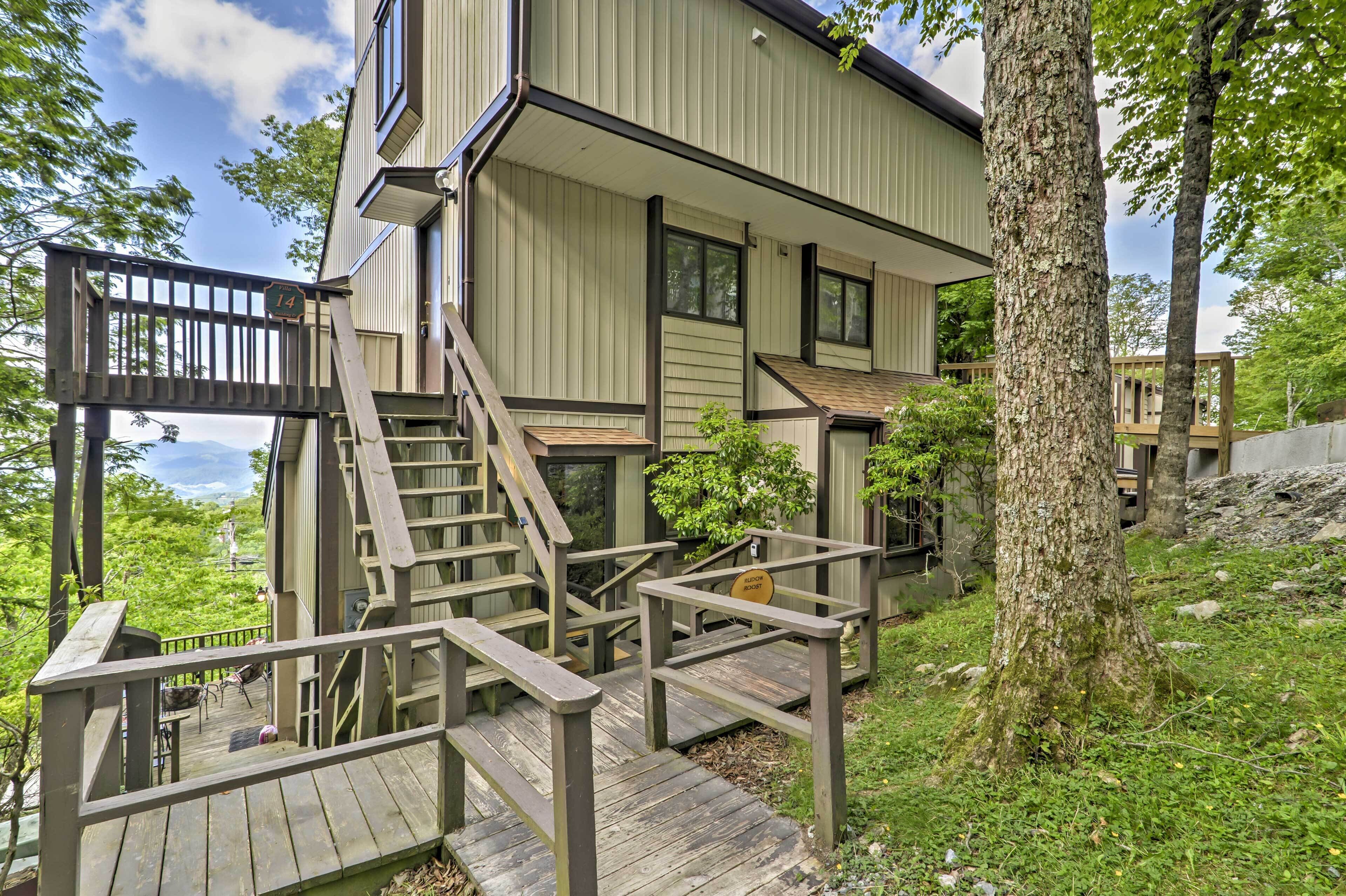 A two-story building with a wooden deck and stairs leading to the entrance.