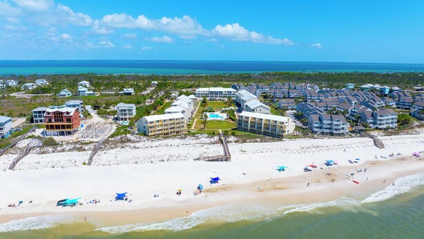 An aerial view of a coastal resort with beachfront properties, a boardwalk, and a clear view of the ocean. - Gated Community, Pool, Green Space, Great Beach Access - SeaCliff (Cape San Blas)