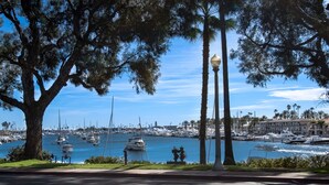 A marina with numerous boats docked, surrounded by trees and buildings. - Cheery and bright upstairs unit is a perfect beach getaway! (Newport Beach)