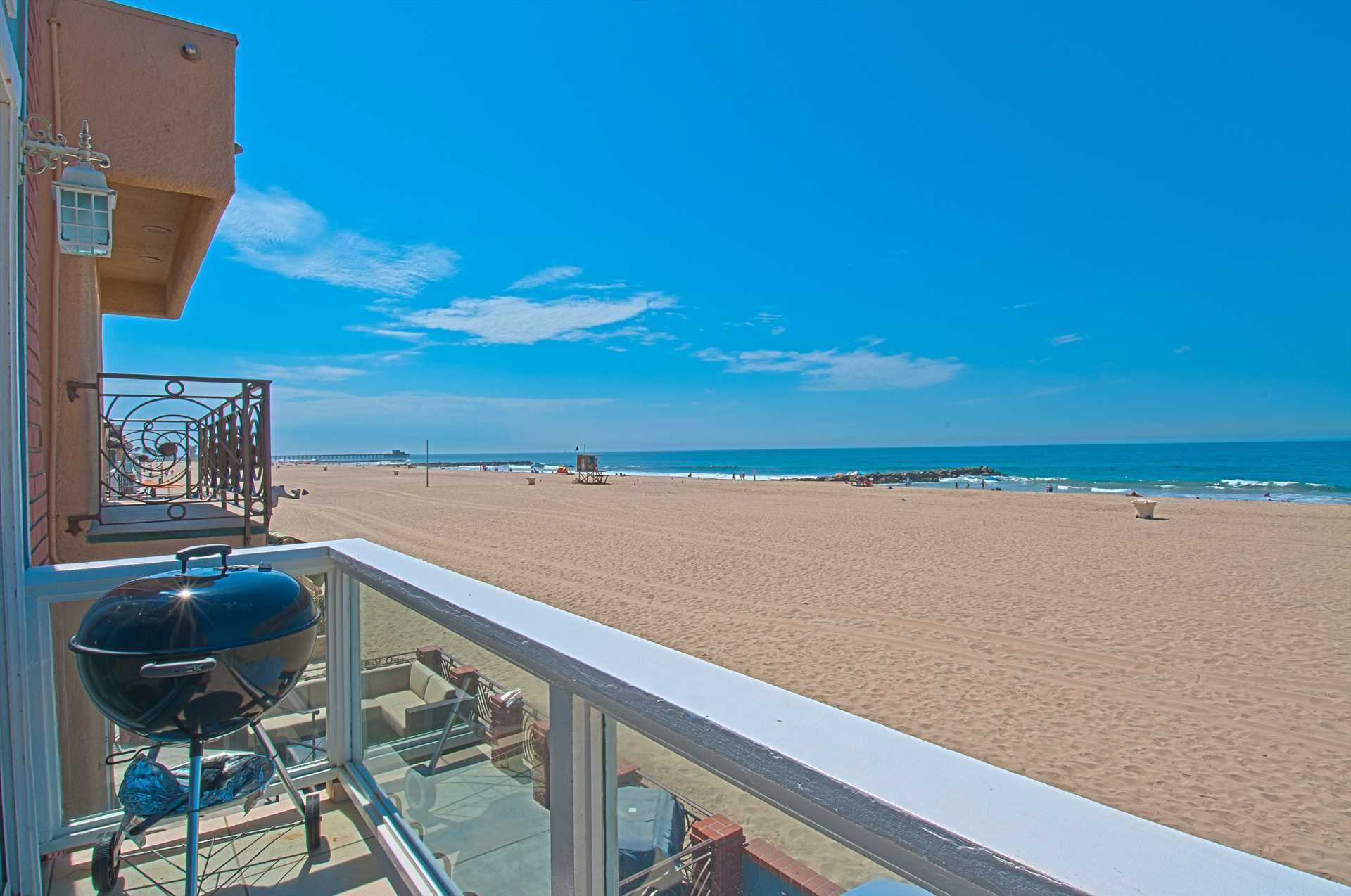 Un balcone con vista su una spiaggia sabbiosa e l'oceano.