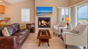 A living room with a fireplace, a sofa, a chair, and a coffee table. - Cheery and bright upstairs unit is a perfect beach getaway! (Newport Beach)