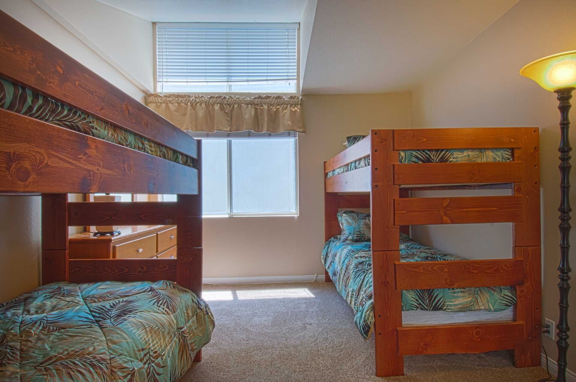 Una habitación con dos literas, una ventana con persianas, una lámpara y un escritorio pequeño.