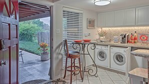 A kitchen with a built-in washer and dryer, a dining table with chairs, and a small patio area with a potted plant. - 5 Mi to Dtwn: Austin Gem w/ Pool, Pets Welcome (Austin)