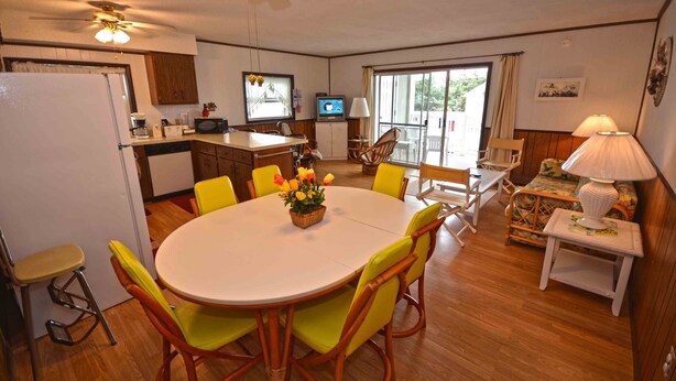 A compact kitchen with a refrigerator, microwave, and a dining area with a round table and chairs. - Spacious, yet cozy 3 bedroom condo with free WiFi and a balcony located midtown on the ocean block just a short walk to the beach! (Ocean City)