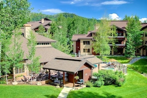 A resort with multiple buildings, outdoor seating areas, and a pool.