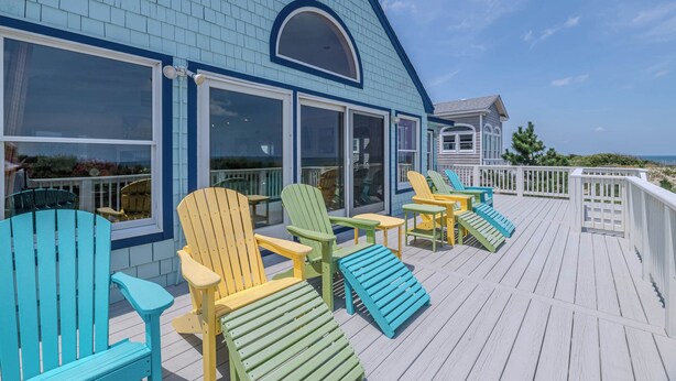 A deck with Adirondack chairs and a view of the ocean. - Terning Point - Corolla, Crown Point, Oceanfront, 20 Yds to Beach, Pool, Hot Tub, Pets OK (Corolla)