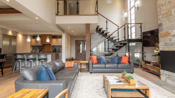 Un espacio habitable amplio con cocina moderna, una escalera y una zona de estar acogedora.
