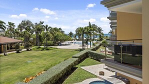 Een resort met een zwembad, palmbomen en uitzicht op de oceaan.