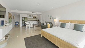 Een moderne hotelkamer met een groot bed, een zithoek en een kitchenette.