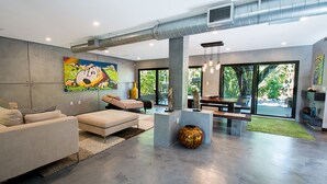 A modern living room with a large window, a sofa, a coffee table, and a decorative vase.
