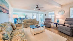 A living room with a sofa, armchairs, a coffee table, and a ceiling fan. - Summer Camp - Corolla, Crown Point, Oceanfront, 70 Ft to Beach, Community Pool, Hot Tub, Pets OK (Corolla)