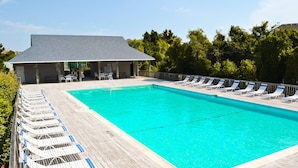 A rectangular swimming pool with a wooden deck and lounge chairs. - Summer Camp - Corolla, Crown Point, Oceanfront, 70 Ft to Beach, Community Pool, Hot Tub, Pets OK (Corolla)