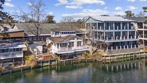 A waterfront property with multiple buildings, including a large multi-story house with balconies and a smaller house with a dock. - *Fall into Savings-20% Off New Bookings thru 2026* (Myrtle Beach)