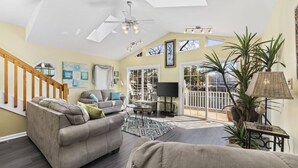 A spacious living room with a high ceiling, a ceiling fan, a large window, and a view of the outdoors. - *Fall into Savings-20% Off New Bookings thru 2026* (Myrtle Beach)